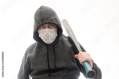 Fényképezés Criminal in a hoodie and mask with a black baseball bat on his shoulder
