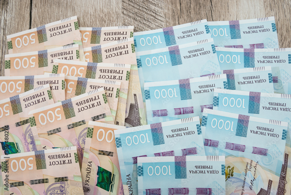 a lot of banknotes in denominations of 1000 and 500 hryvnia. Money background. Financial concept. Ukrainian money on a wooden background. Close-up.