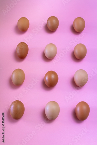 Eggs in kitchen top view pink background - natural food pattern