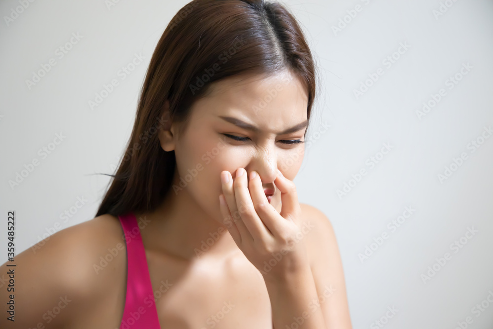 asian woman covering her nose for bad smell, concept of stink thing, bad breath, unpleasant smell, rotten food, odor, body bad smell; young adult southeast asian woman model asian woman covering her nose for bad smell, concept of stink thing, bad breath, unpleasant smell, rotten food, odor, body bad smell; young adult southeast asian woman model