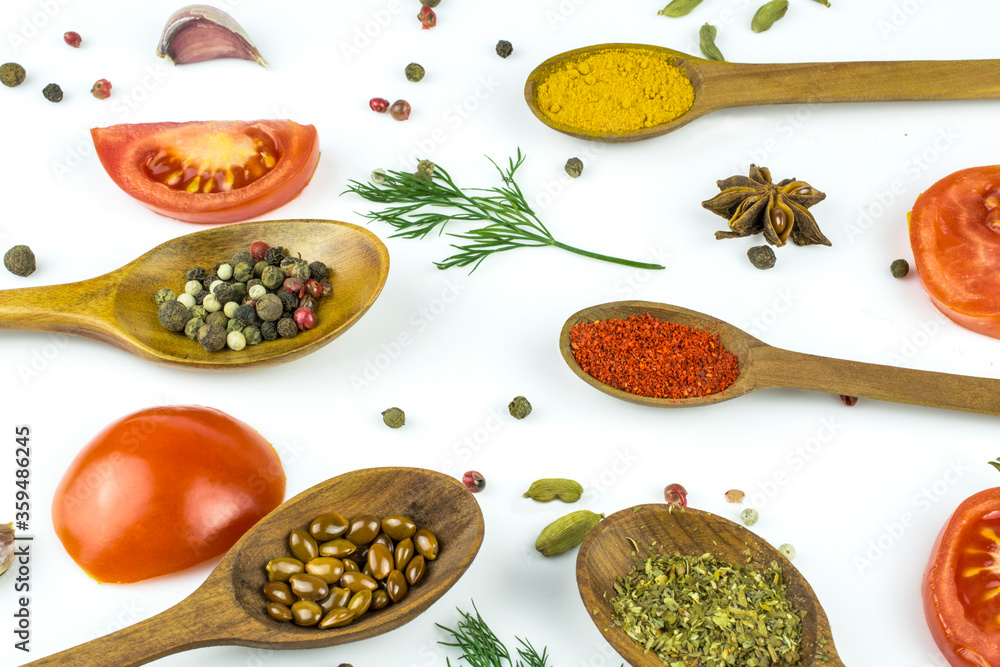 Spoons with spices and seasonings, fresh tomatoes, garlic and dill isolated on a white background. Spoons with spices and seasonings, fresh tomatoes, garlic and dill isolated on a white background.