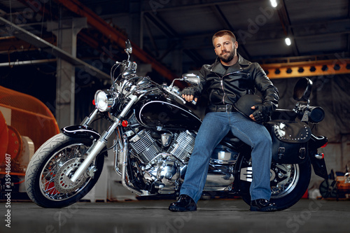 Bearded motorcyclist in black leather clothing with his motorbike © fotofabrika
