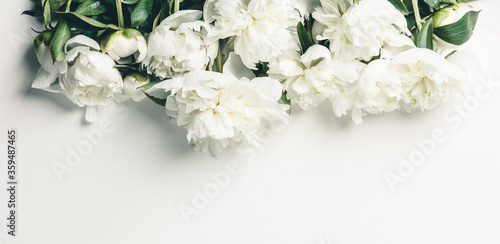 Flat-lay of Beautiful peony flowers over white background, top view, copy space