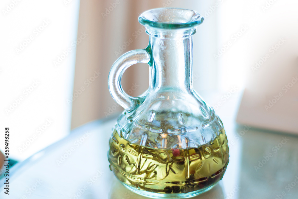 Olive oil with spices and herbs in a glass decanter. Seasoning for dishes and salads. The photo Olive oil with spices and herbs in a glass decanter. Seasoning for dishes and salads. The photo