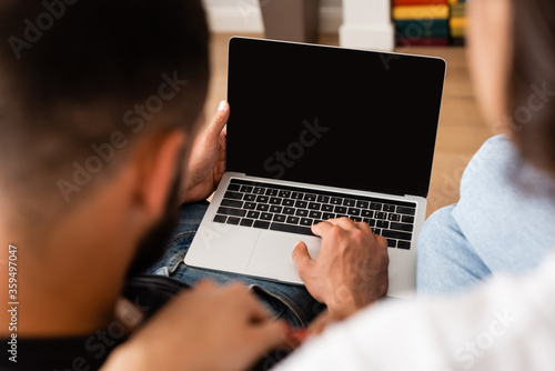 selective focus of freelancers using laptop with blank screen at home