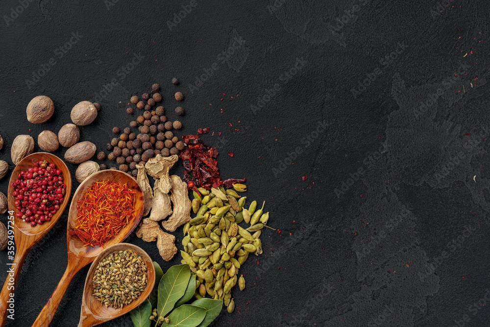 Wooden spoons with various spices on black background Wooden spoons with various spices on black background
