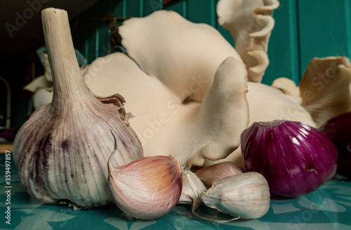 Oyster mushrooms on the kitchen table.Oyster mushrooms mushrooms and red onion and garlic