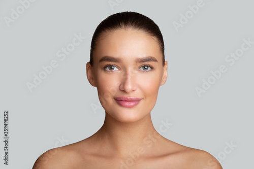 Billede på lærred Woman with perfect skin looking at camera at gray studio