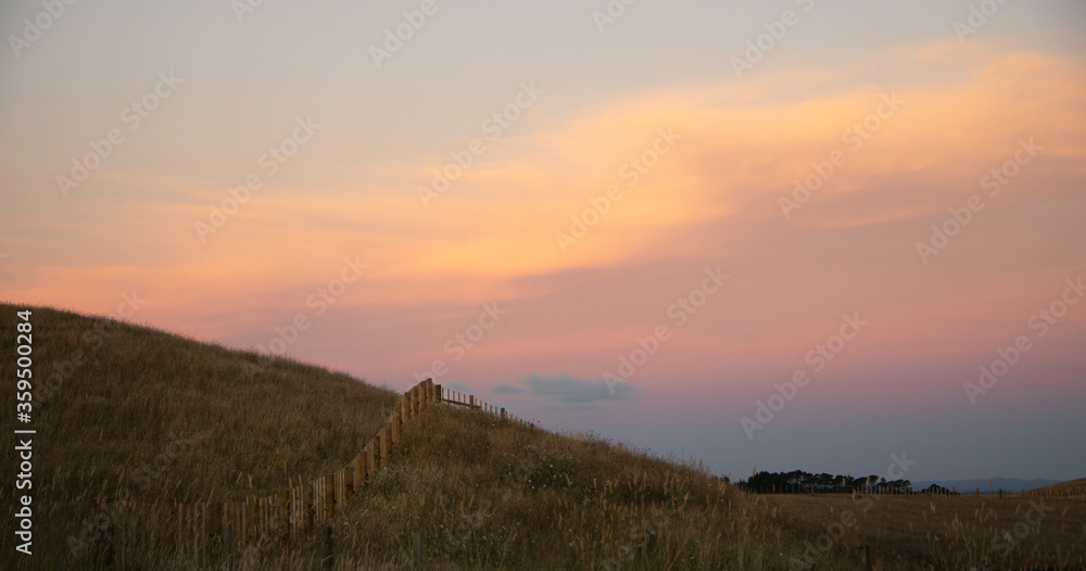 Farm fences on the hill at sunset with beautiful pastel sky