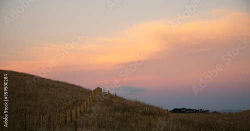 Farm fences on the hill at sunset with beautiful pastel sky