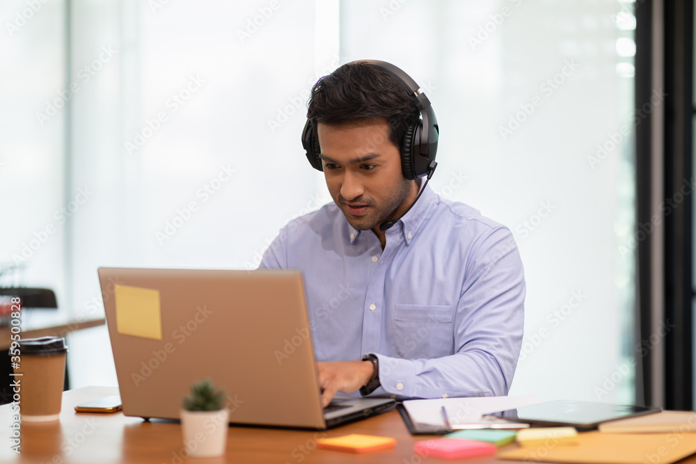 Young business indian man meeting with business team via video conference call at Home,Hand up Greetings with group in online video call Young business indian man meeting with business team via video conference call at Home,Hand up Greetings with group in online video call