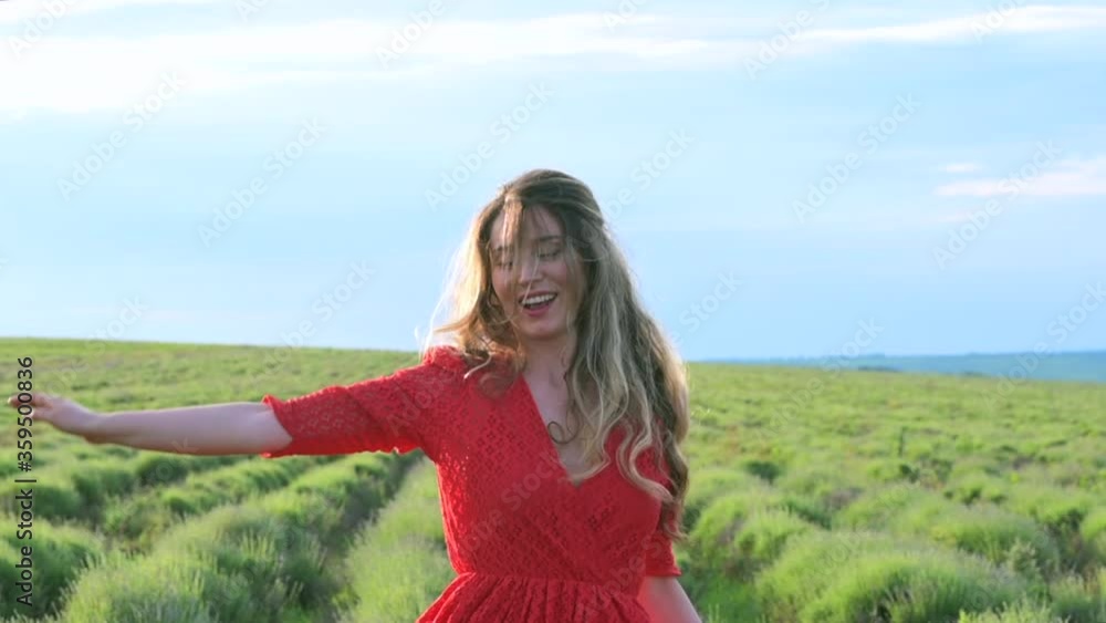 Happy woman in red dress dancing and jumping in lavender field, sun glowing, shallow soft focus, slow motion Happy woman in red dress dancing and jumping in lavender field, sun glowing, shallow soft focus, slow motion