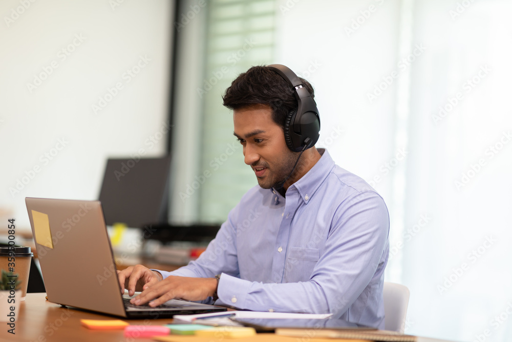 Young business indian man meeting with business team via video conference call at Home,Hand up Greetings with group in online video call Young business indian man meeting with business team via video conference call at Home,Hand up Greetings with group in online video call