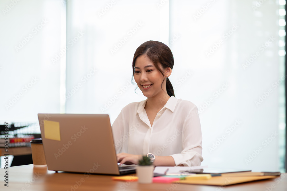 Happy Asian business woman working with laptop and smile Happy Asian business woman working with laptop and smile