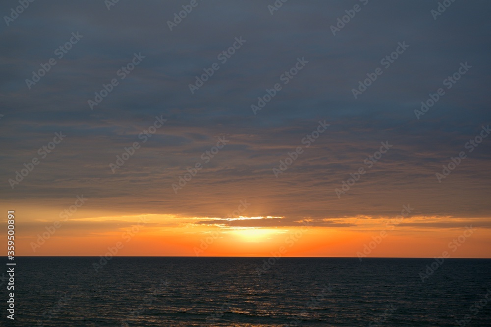 A narrow strip of clear sky over the horizon. The sky is covered with dense clouds.