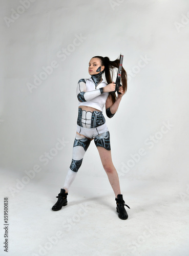 beautiful girl in a robot suit plays with scissors and hair