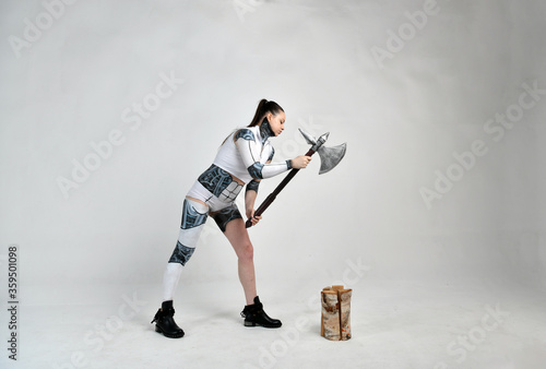 beautiful girl in a suit of a robot ax chopped wood