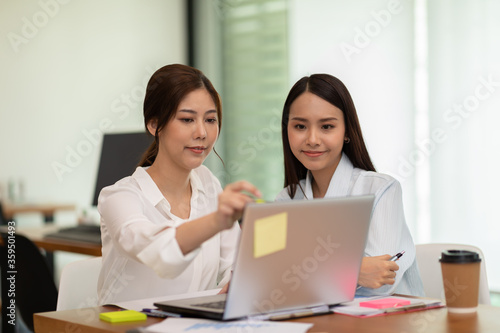two young business woman Startup coworkers working together to get ideas and marketing at office,Business Startup Diversity Brainstorming Concept