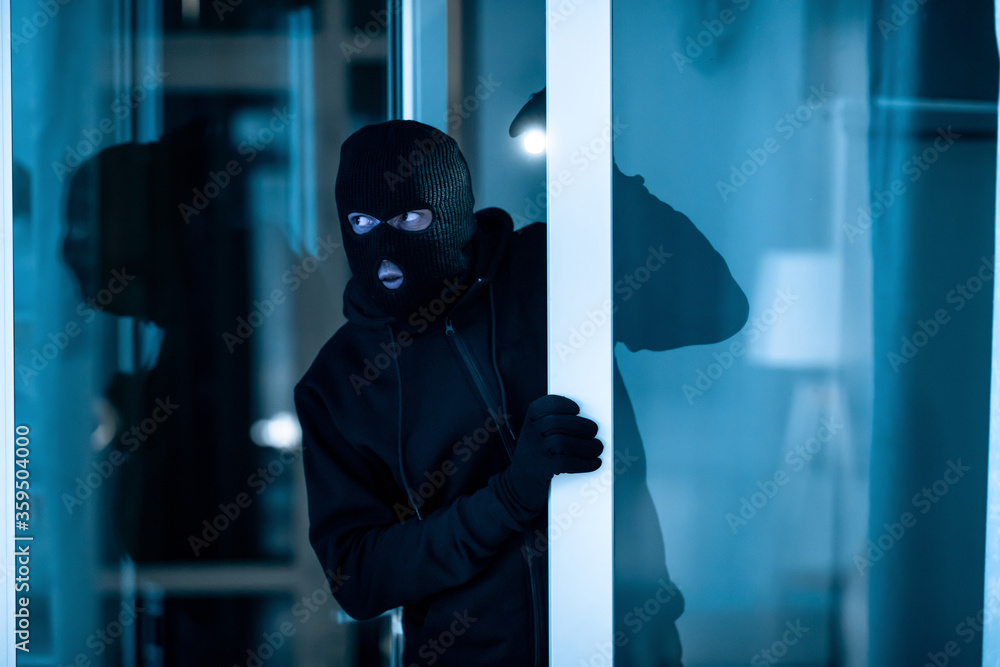 Thief breaking into apartment or office to steal something - obrazy, fototapety, plakaty 