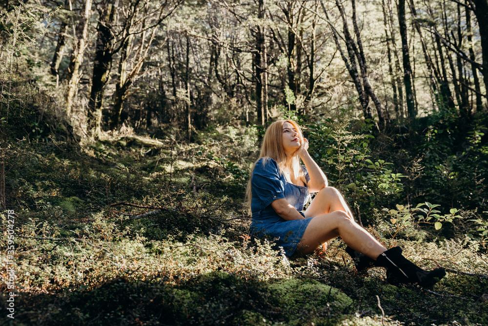 Beautiful asian woman dressed blue jean relaxing in rainforest with sunlight. Beautiful asian woman dressed blue jean relaxing in rainforest with sunlight.