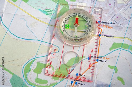 travel sport compass lies on a map to determine azimuth movement