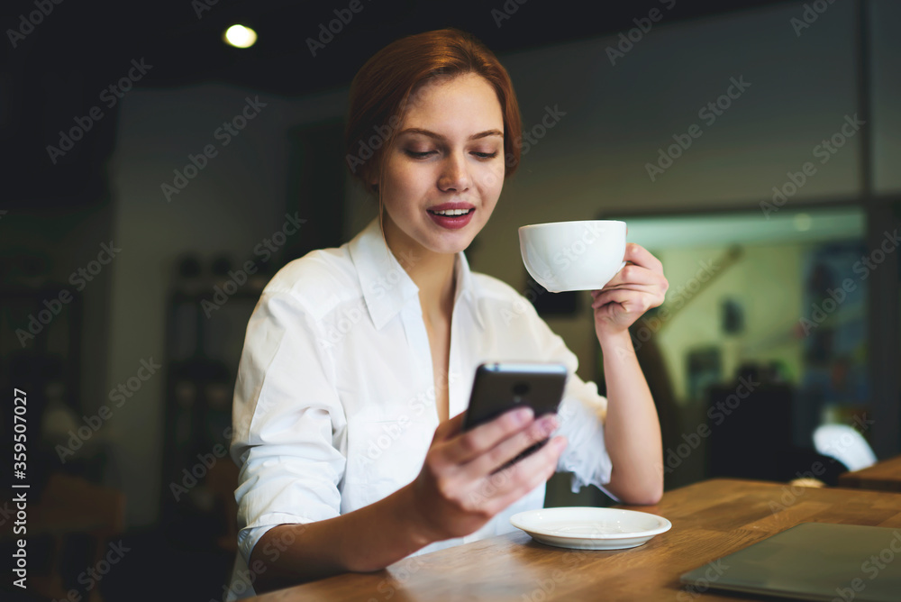 Young smiling female business woman have online conversation with partners arranging conference meeting to discuss working schedule using smartphone connected to free wireless internet in wifi zone Young smiling female business woman have online conversation with partners arranging conference meeting to discuss working schedule using smartphone connected to free wireless internet in wifi zone