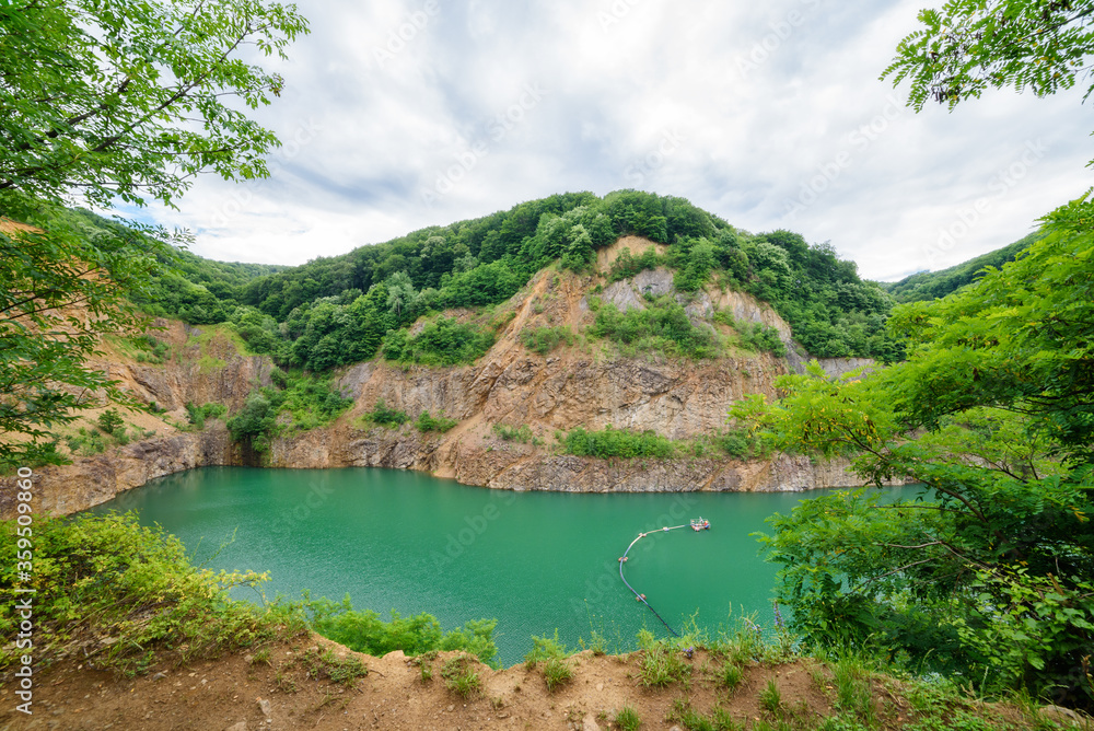 Beautiful Lake Ledinci (serbian: Ledinacko jezero) near Fruska Gora in Serbia, once there was a stone pit. Beautiful vibrant green deep mountain lake, hidden and surrounded by rocks and woods. Beautiful Lake Ledinci (serbian: Ledinacko jezero) near Fruska Gora in Serbia, once there was a stone pit. Beautiful vibrant green deep mountain lake, hidden and surrounded by rocks and woods.