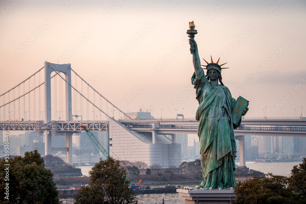 Fototapeta premium Standing only 40 feet tall, the Tokyo Statue of Liberty seems much larger as it stands near Tokyo Bay and and famous Rainbow Bridge.