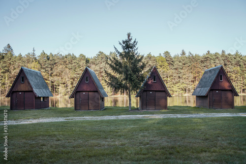 Fototapeta Naklejka Na Ścianę i Meble -  empty wooden cabin village near the pond and the coniferous forest in the south of Czech republic