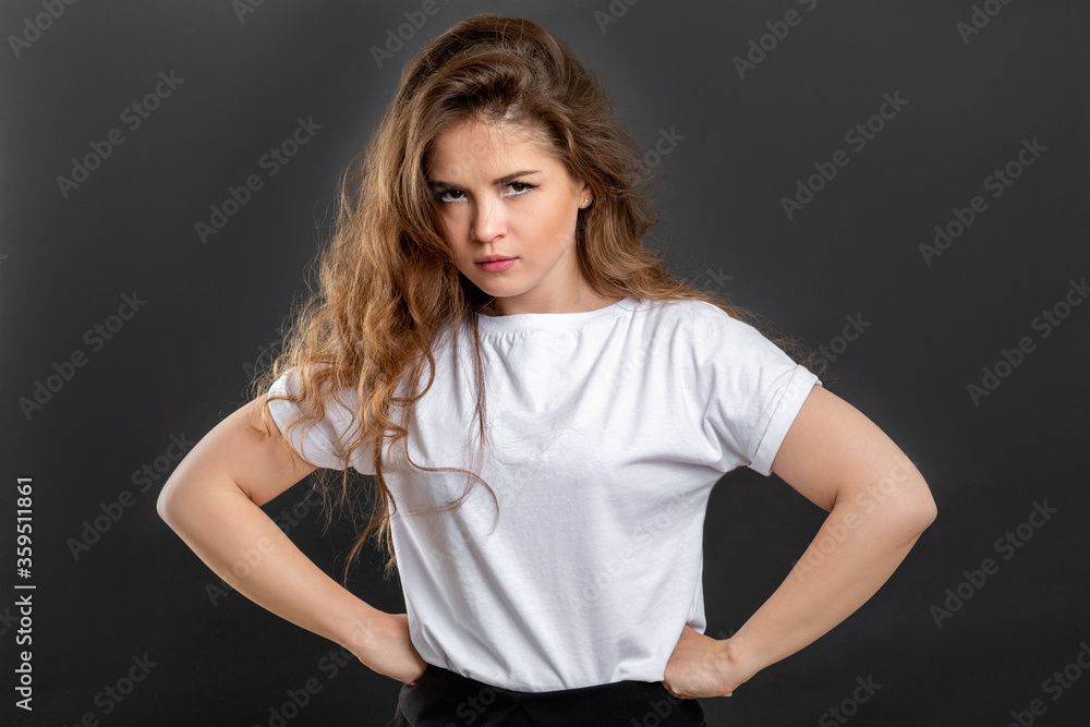Mad woman portrait. Protest conflict. Angry lady with hands on hips isolated on gray background. Mad woman portrait. Protest conflict. Angry lady with hands on hips isolated on gray background.