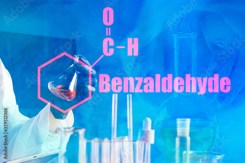 Benzaldehyde. The inscription benzaldehyde and molecular formula on a blue chemical background. Synthesis of almond acid. Colorless liquid with the smell of bitter almonds or Apple seeds. photo