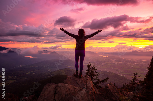 Adventurous Girl on top of a Rocky Mountain overlooking the beautiful Canadian Nature Landscape during a dramatic Sunset. Taken in Chilliwack, East of Vancouver, British Columbia, Canada.