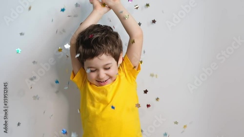 happy birthday child. Photo of charming cute fascinating nice little boy blowing confetti at you to show her festive mood with emotional face expression. stock footage. Slow Motion video. Close up