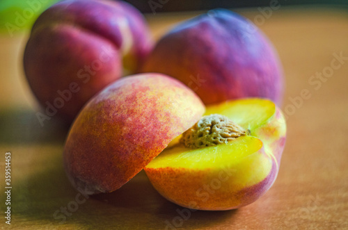 fresh peaches on a wooden background, Fruits of organic peaches whole and halves photo