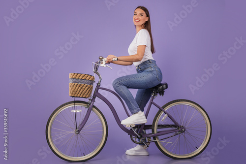 Beautiful woman riding her bike at studio, isolated © Prostock-studio
