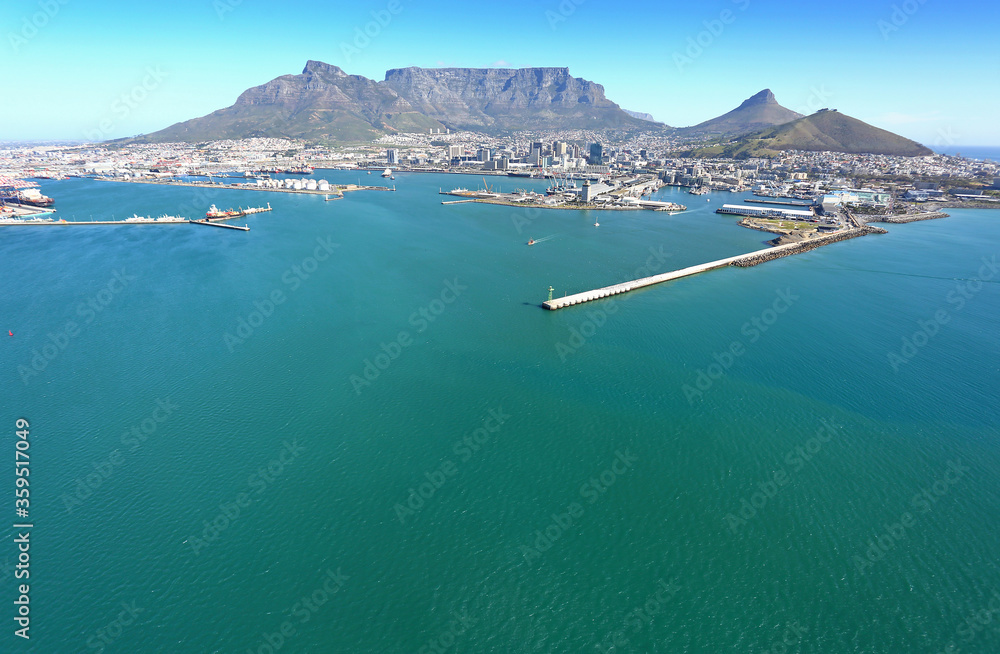 Naklejka premium Cape Town, Western Cape / South Africa - 09/05/2019: Aerial photo of a vessel with Cape Town Harbour and Table Mountain in the background