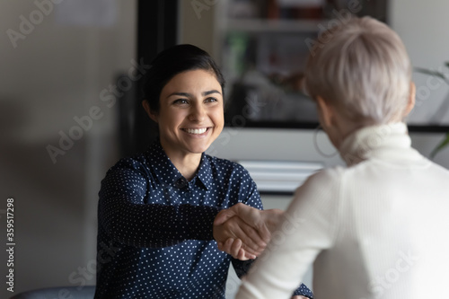 Happy employer HR manager shaking hands with indian job seeker welcoming vacancy applicant. Successful manager making deal with partner, good positive first impression, start business meeting concept photo