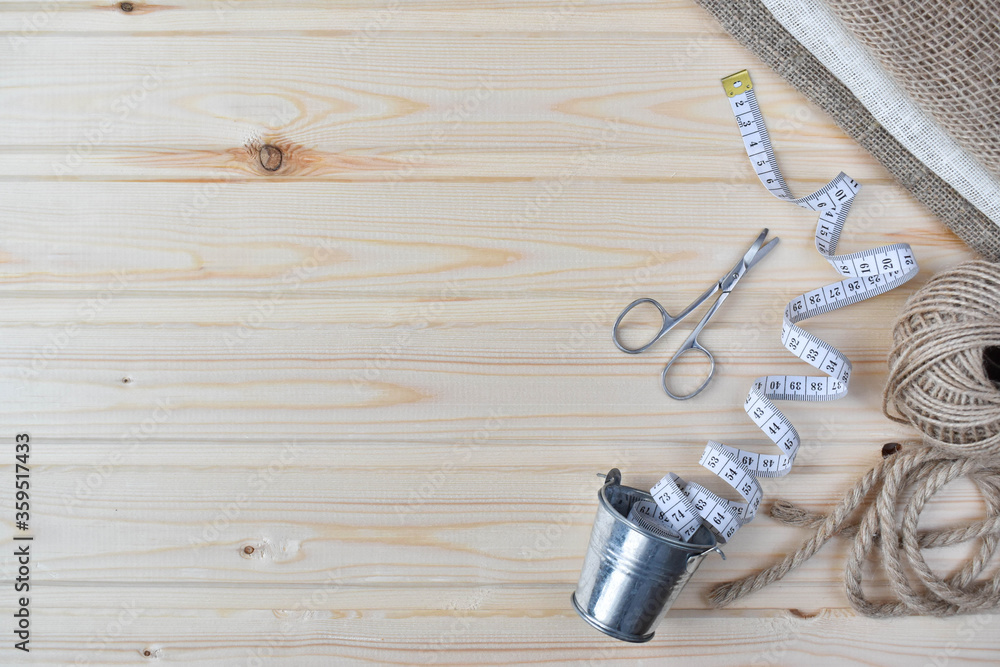 Naklejka premium Sewing supplies on a wooden background. Flat lay