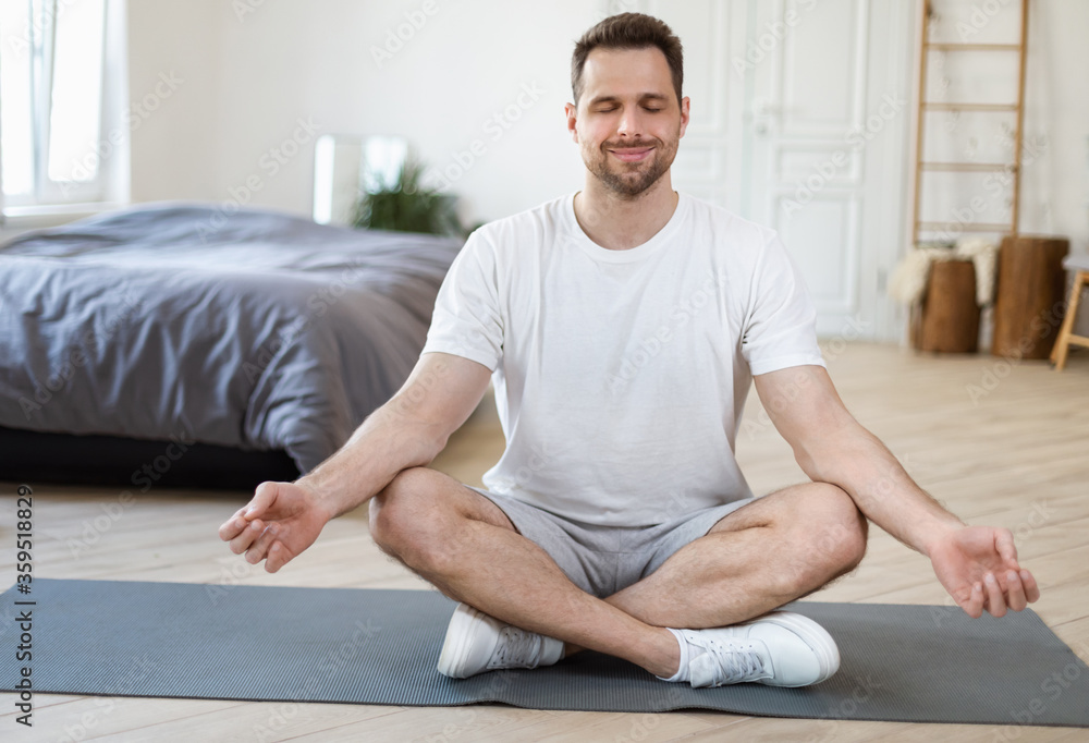 Man Meditating Sitting In Lotus Position Relaxing At Home Man Meditating Sitting In Lotus Position Relaxing At Home