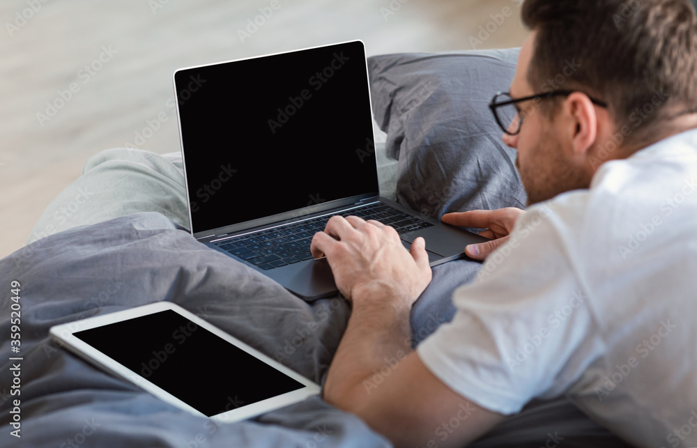 Man With Laptop And Tablet Working In Bed Indoors, Mockup