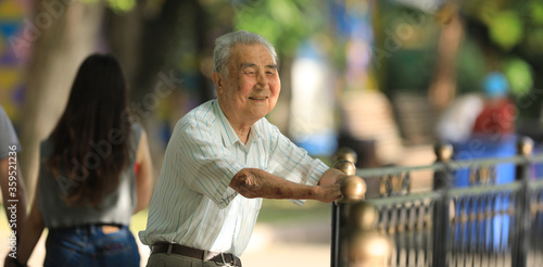 old man smiles and rests outdoors in summer