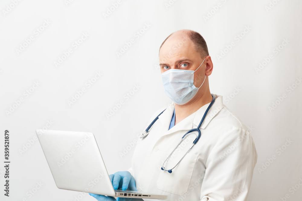 Doctor in mask working with laptop. Telemedicine. Computer technology in medicine Doctor in mask working with laptop. Telemedicine. Computer technology in medicine
