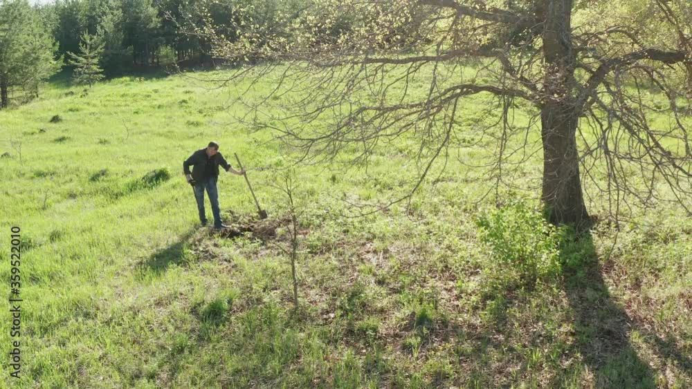 A guy with a metal detector is looking for a treasure against the background of the forest. A man is looking for metal with a metal detector. A guy with a metal detector is looking for a treasure against the background of the forest. A man is looking for metal with a metal detector.