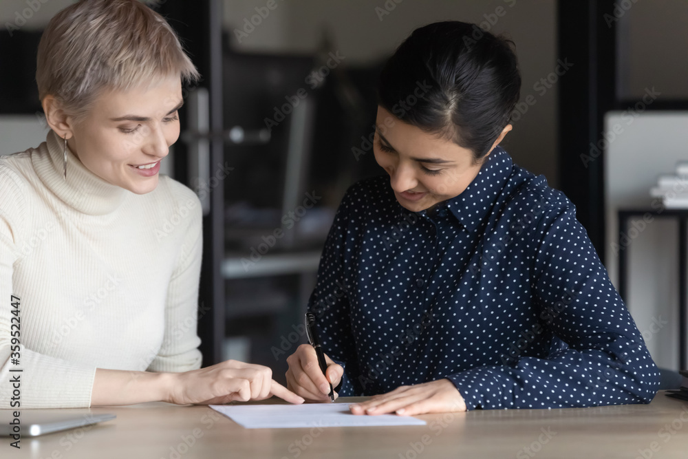 Indian satisfied customer woman signing contract make deal with insurer ends successful effective business meeting in office, got hired applicant feels happy puts signature on hiring agreement concept Indian satisfied customer woman signing contract make deal with insurer ends successful effective business meeting in office, got hired applicant feels happy puts signature on hiring agreement concept