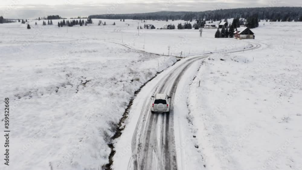 White Car Taking Drive on Snowy Road During Winter Season Along the Mountains White Car Taking Drive on Snowy Road During Winter Season Along the Mountains
