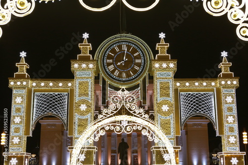 New Year's decor on street. Architecture of Moscow city, Russia. VDNKh, Exhibition of Achievements of National Economy, Central VDNKh Pavilion № 1. Christmas clock. Night lights and holiday decoration photo