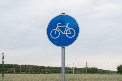  straßenschild fahrrad zeigt verkehrssymbol rad in landschaft verkehrszeichen radfahrer auf blauem hintergrund