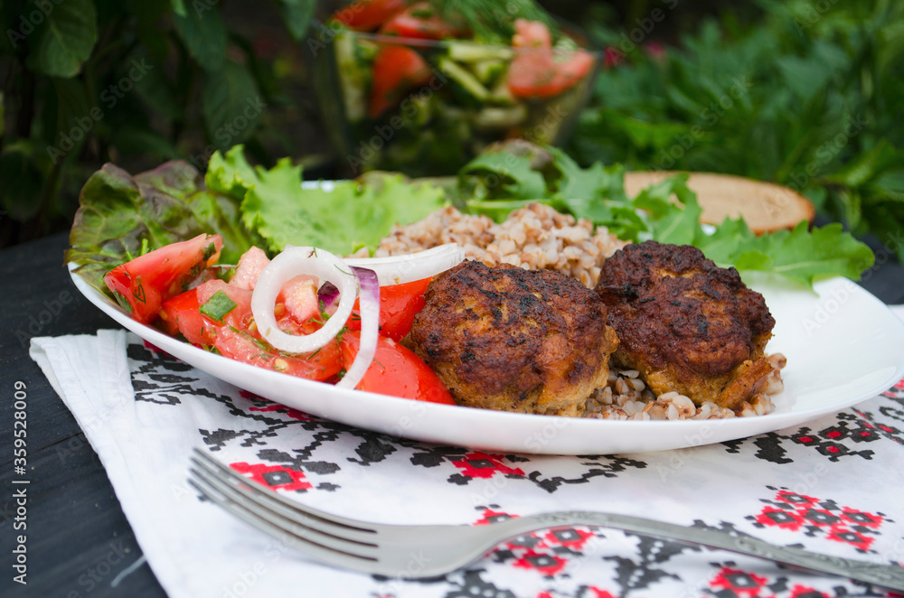 Cutlets with buckwheat porridge and salad. Healthy eating concept. Macro photo. Top view and side view. Erupny plan of the dish. Cutlets with buckwheat porridge and salad. Healthy eating concept. Macro photo. Top view and side view. Erupny plan of the dish.
