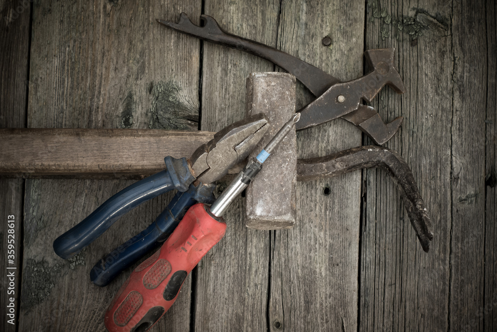 Retro set of equipment for working with wood. Hammer, screwdriver, chisel, pliers on a background of textured wooden boards. The view from the top. Retro set of equipment for working with wood. Hammer, screwdriver, chisel, pliers on a background of textured wooden boards. The view from the top.