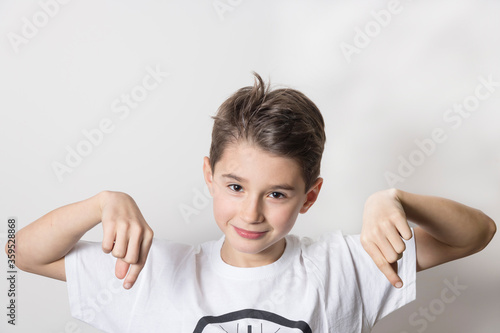 Obraz na płótnie Teenage boy in white shirt. Portrait in studio. Funny faces. w salonie